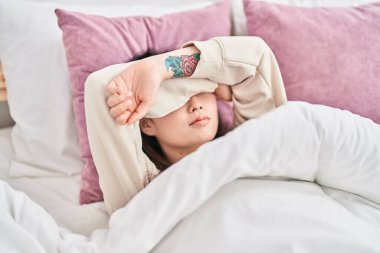 Chinese woman lying on bed crying at bedroom