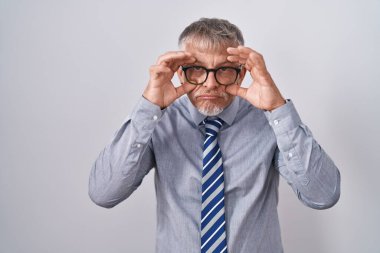 İspanyol iş adamı, gri saçlı, gözlüklü, parmaklarıyla gözlerini açmaya çalışan, uykulu ve yorgun bir sabah yorgunluğu çeken. 