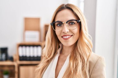 Genç sarışın iş kadını ofiste kendine güvenen gülümseyen