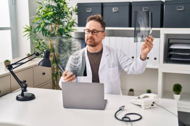 Kafkasyalı genç bir doktor klinikteki masada oturuyor.