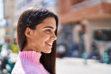 Sokakta kendine gülen genç İspanyol kadın.