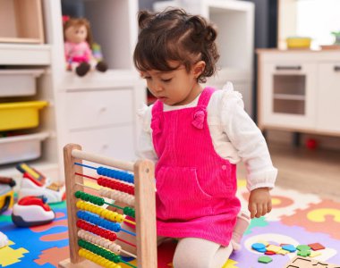 Anaokulunda Abaküs 'le oynayan sevimli İspanyol kız.