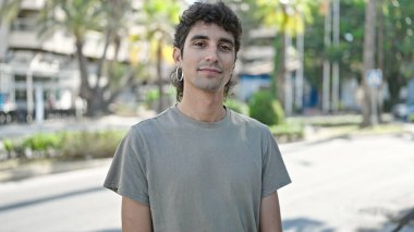 Sokakta ciddi bir ifadeyle duran İspanyol genç adam.