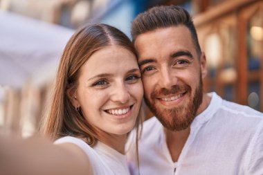 Man and woman couple smiling confident make selfie by camera at street