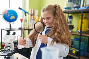 Loupe 'un laboratuvar sınıfındaki sevimli sarışın kız öğrenci örneği.