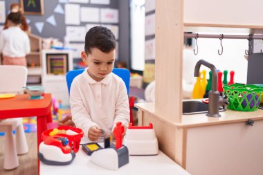 Anaokulunda süper market oyunu oynayan sevimli İspanyol çocuk.