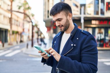 Sokakta akıllı telefon kullanan, kendine güvenen genç bir İspanyol.