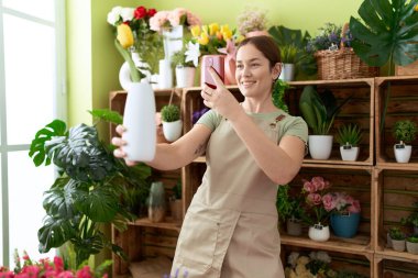 Çiçekçide çiçekçiyle fotoğraf çektiren güzel bir kadın.