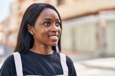 Genç Afrikalı Amerikalı kadın gülümsüyor. Kendine güveni tam.