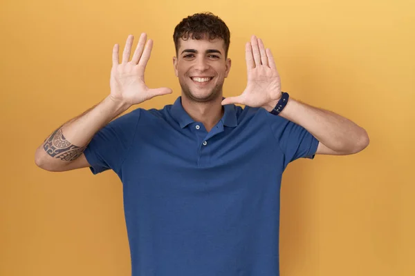 Young Hispanic Man Standing Yellow Background Showing Pointing Fingers Number — Zdjęcie stockowe