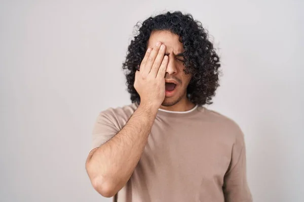 Hispánec Kudrnatými Vlasy Stojící Nad Bílým Pozadím Unaveně Zírající Zakrývající — Stock fotografie