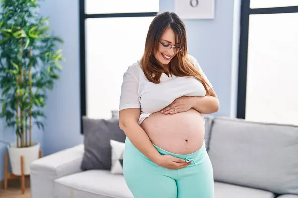 Young Pregnant Woman Smiling Confident Touching Belly Home — Stok fotoğraf
