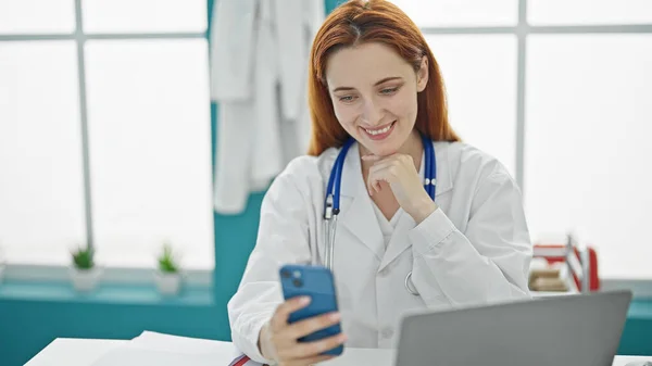 Młoda Ruda Lekarz Robi Wideo Rozmowy Smartfonem Klinice — Zdjęcie stockowe