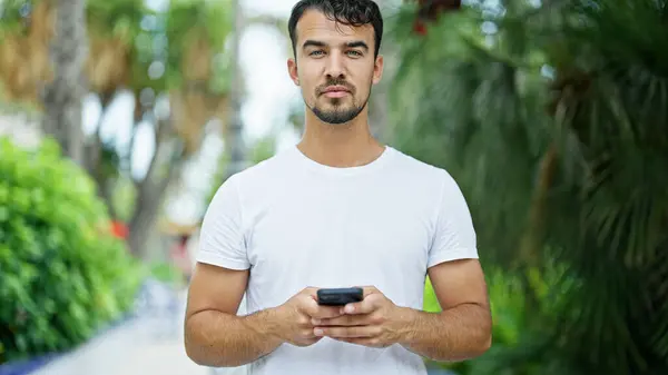 Jonge Spaanse Man Met Behulp Van Smartphone Met Serieuze Expressie — Stockfoto