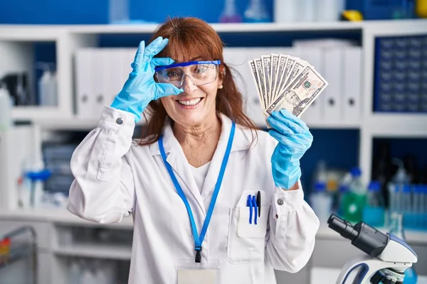 Orta Yaşlı Spanyol Kadın Laboratuvarda Çalışıyor Elinde Dolarlarla Dolarlar Tutarak — Stok fotoğraf