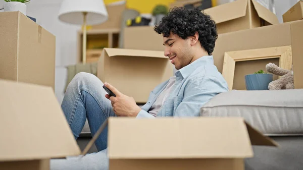 Jovem Latino Usando Smartphone Sentado Chão Sorrindo Uma Nova Casa — Fotografia de Stock