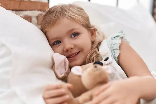 Sevimli Sarışın Kız Yatak Odasında Bebek Tutuyor — Stok fotoğraf