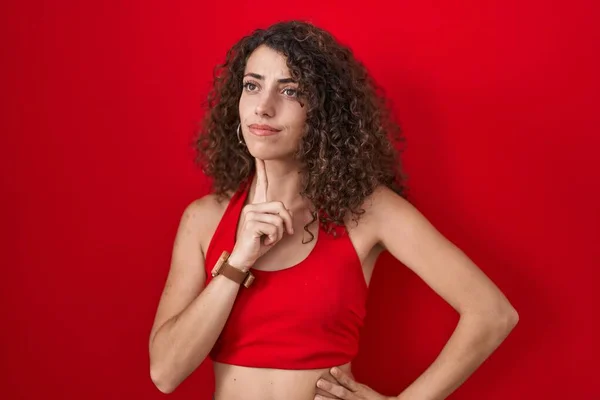 Mujer Hispana Con Pelo Rizado Pie Sobre Fondo Rojo Pensando — Foto de Stock
