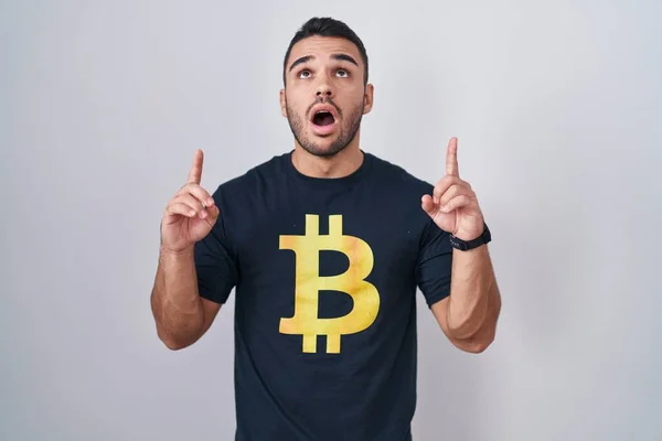 Joven Hombre Hispano Con Camiseta Bitcoin Asombrado Sorprendido Mirando Hacia —  Fotos de Stock