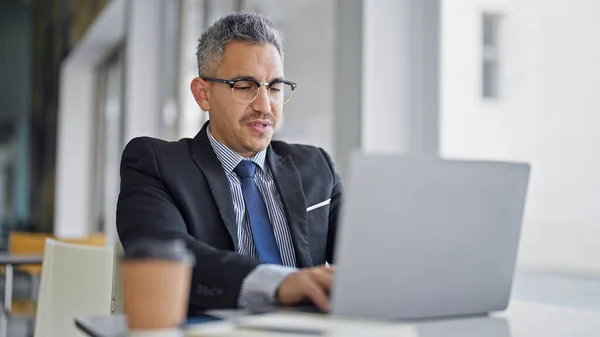 若いヒスパニック系男性ビジネスワーカーがオフィスでラップトップを使用してメガネを着用 — ストック写真