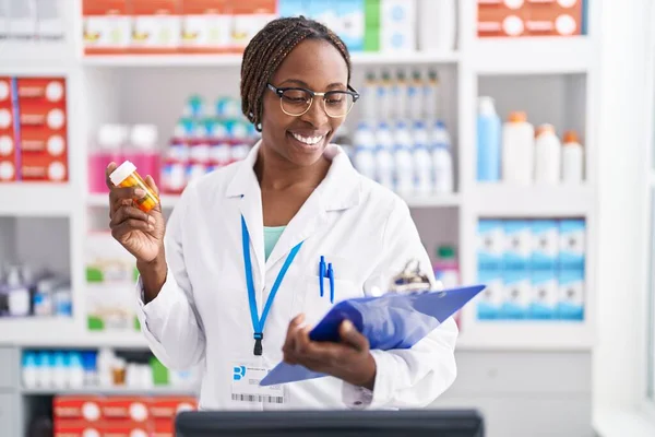 Afrikansk Amerikansk Kvinna Farmaceut Håller Piller Flaska Läsa Dokument Apotek — Stockfoto