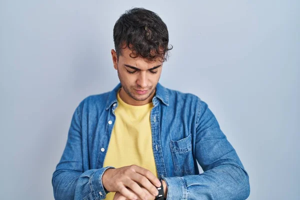 Young Hispanic Man Standing Blue Background Checking Time Wrist Watch — Stock fotografie