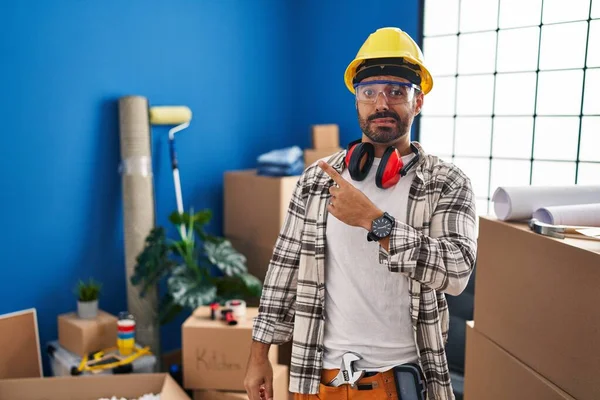 Evde sakallı ve sakallı genç bir adam endişeli ve endişeli bir ifade takınıyor. 