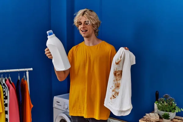 Çamaşır Odasında Kirli Tişört Deterjan Tutan Genç Sarışın Adam — Stok fotoğraf