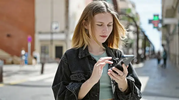 Νεαρή Ξανθιά Γυναίκα Που Χρησιμοποιεί Smartphone Σοβαρό Πρόσωπο Στο Δρόμο — Φωτογραφία Αρχείου