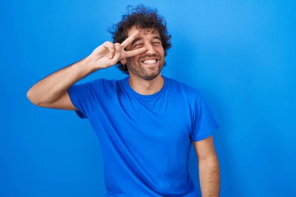 Hispanic Young Man Standing Blue Background Doing Peace Symbol Fingers — Fotografia de Stock