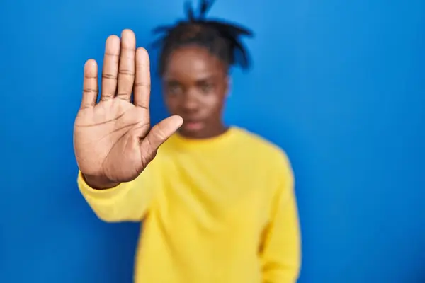 美丽的黑人妇女站在蓝色的背景上 用手掌停止歌唱 用消极而严肃的手势警告人 — 图库照片
