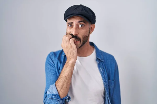 髭を生やしたヒスパニック系の男性は 口の爪をかむ上で手でストレスと緊張を見て孤立した背景の上に立っている 不安の問題 — ストック写真