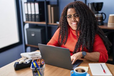 Ofiste çalışırken dizüstü bilgisayar kullanan Afrikalı Amerikalı iş kadını.