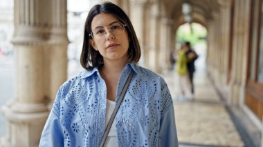 Viyana sokaklarında ciddi bir ifadeyle duran genç, güzel İspanyol kadın.
