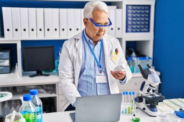 Üst düzey bilim adamı laboratuvarda dizüstü bilgisayar kullanıyor.