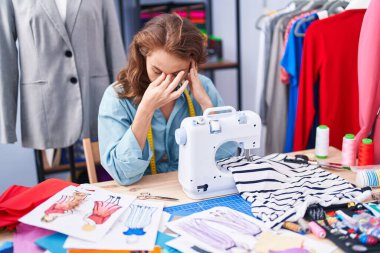 Terzi dükkanında dikiş makinesi kullanan genç ve güzel bir İspanyol kadın.