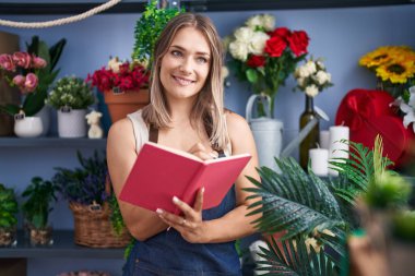 Çiçekçide kendine güvenen beyaz bir kadın çiçekçi.