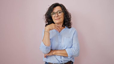 Middle age hispanic woman smiling confident standing over isolated pink background