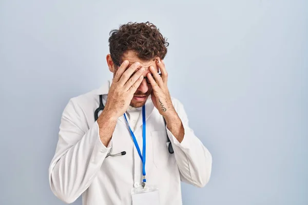 年轻的惊慌失措的男人穿着医生制服和听诊器 脸上挂着忧郁的表情 一边哭一边用手捂住脸 抑郁症的概念 — 图库照片