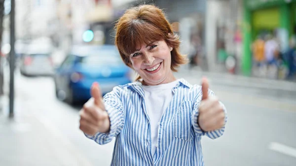 Mujer Mediana Edad Sonriendo Confiado Haciendo Signo Con Pulgares Calle — Foto de Stock