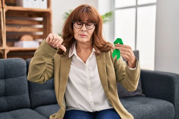 Middle Age Hispanic Woman Holding Support Green Ribbon Angry Face — Stockfoto