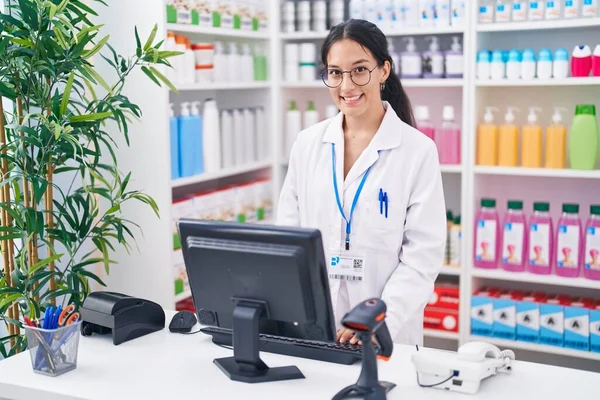 年轻美丽的惊慌失措的女药剂师带着自信的笑容在药店使用电脑 — 图库照片