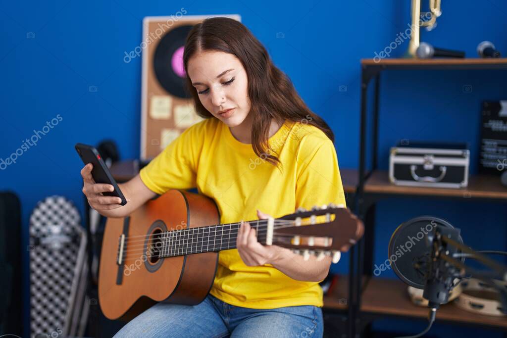 Genç Bayan Müzisyen Müzik Stüdyosunda Akıllı Telefon Kullanarak Klasik Gitar  stok fotoğrafçılık ©Krakenimages.com, telifsiz resim #668520312
