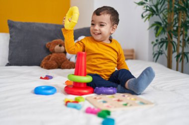 Sevimli İspanyol çocuk yatak odasında oturmuş basketbol oynuyor.