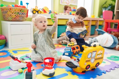 Süpermarket oyunu oynayan sevimli erkek ve kız ve anaokulunda araba oyuncakları.