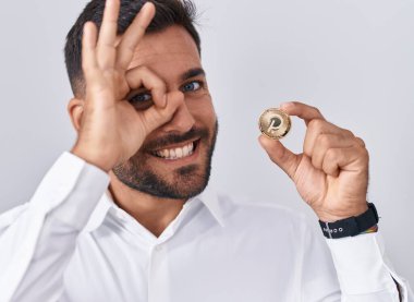 Yakışıklı İspanyol adam elinde polkadot kripto para tutarken gülümsüyor mutlu mesut gülümsüyor. 