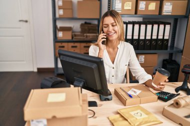 Young hispanic woman ecommerce business worker talking on smartphone at office