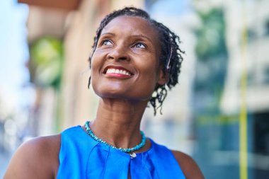 Middle age african american woman smiling confident looking to the side at street