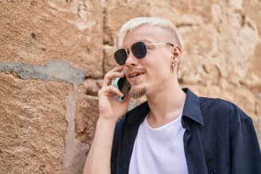 Young caucasian man smiling confident talking on smartphone at street