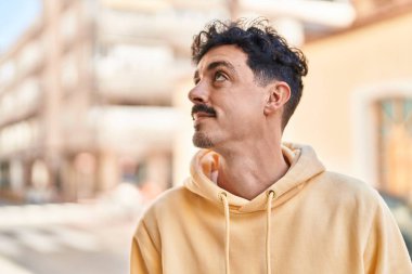 Young caucasian man smiling confident looking to the side at street